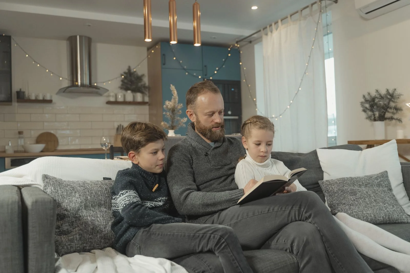Vader leest samen met zijn kinderen een boek